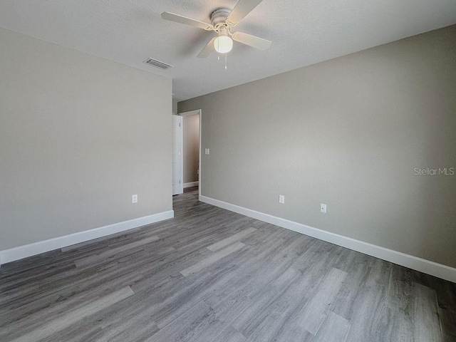 empty room with a textured ceiling, light hardwood / wood-style floors, and ceiling fan