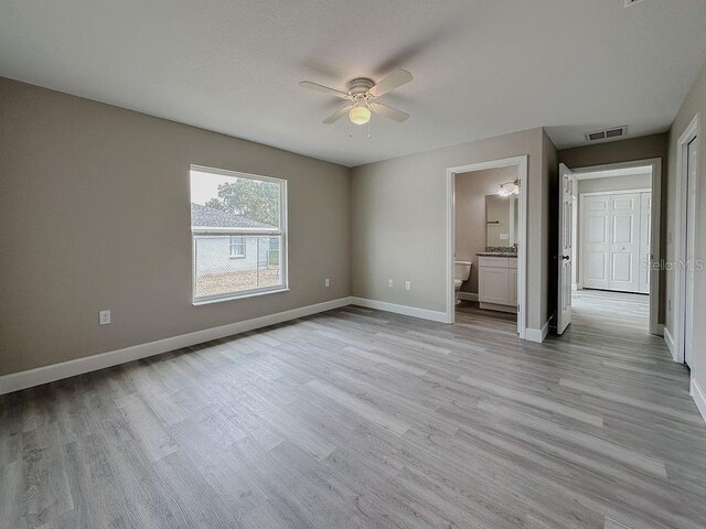 unfurnished bedroom featuring ceiling fan, connected bathroom, and light hardwood / wood-style flooring