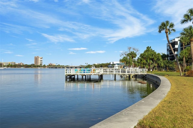 view of dock with a water view and a yard