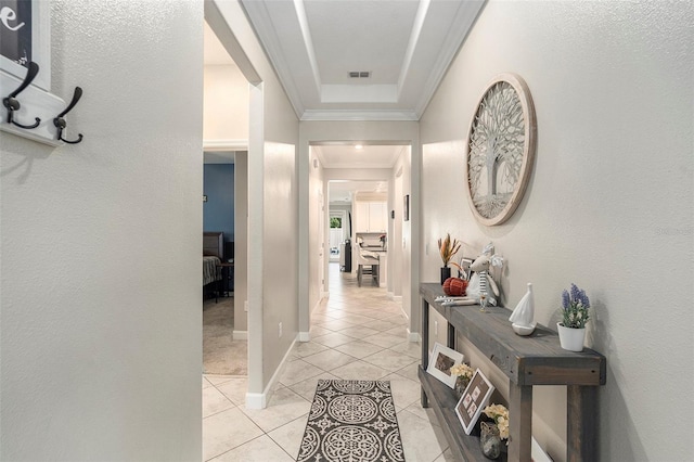 hall with crown molding and light tile patterned floors