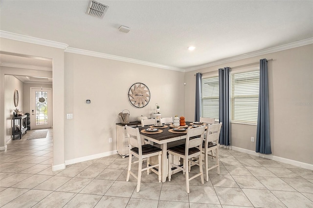 dining room featuring crown molding and light tile patterned floors