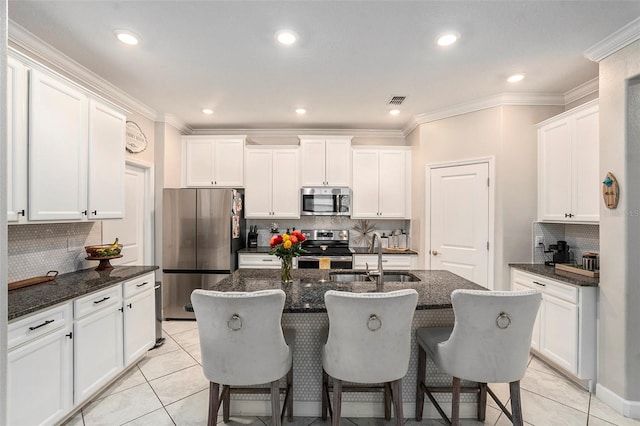 kitchen with decorative backsplash, stainless steel appliances, a center island with sink, and sink