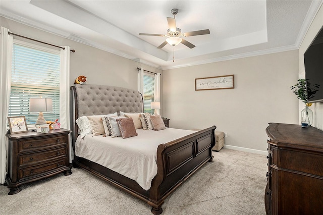 carpeted bedroom with ceiling fan, a raised ceiling, and crown molding