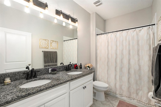 bathroom featuring tile patterned floors, vanity, and toilet