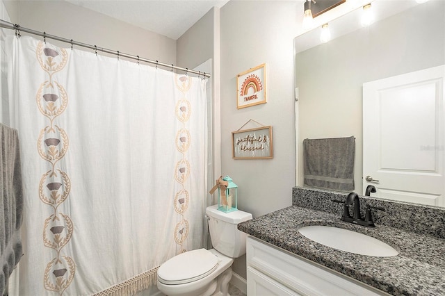 bathroom featuring walk in shower, vanity, and toilet