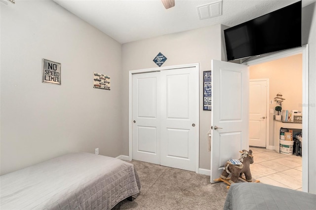 carpeted bedroom featuring ceiling fan and a closet