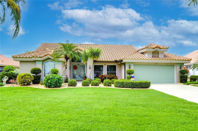 mediterranean / spanish house featuring a front yard and a garage