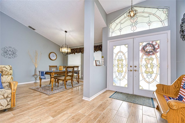 foyer entrance featuring french doors, hardwood / wood-style floors, and a healthy amount of sunlight