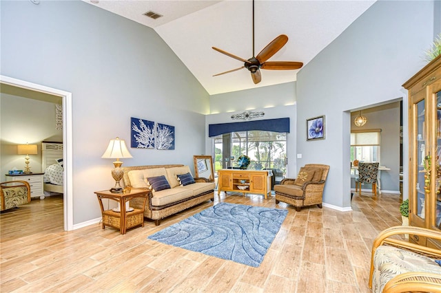 living room with light hardwood / wood-style floors, high vaulted ceiling, and ceiling fan