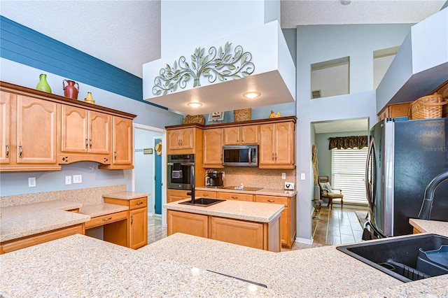 kitchen with light stone countertops, appliances with stainless steel finishes, a textured ceiling, a center island, and high vaulted ceiling