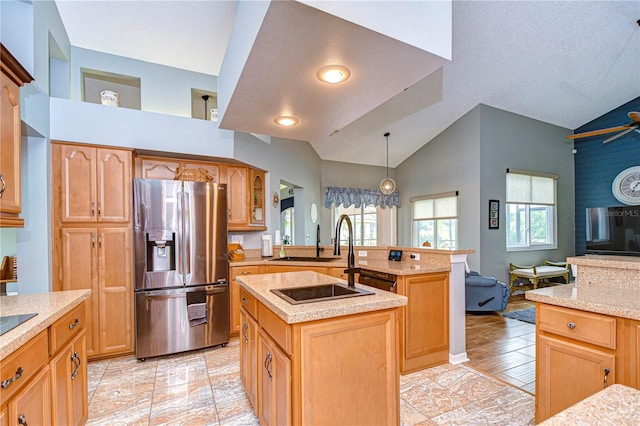 kitchen featuring a kitchen island with sink, hanging light fixtures, stainless steel fridge with ice dispenser, a textured ceiling, and ceiling fan