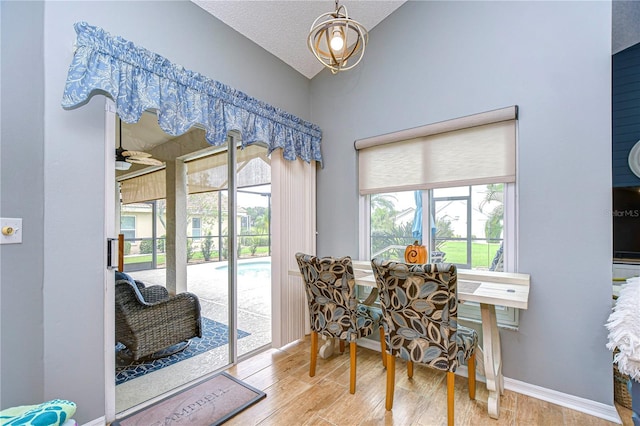 dining area with ceiling fan, a textured ceiling, plenty of natural light, and hardwood / wood-style floors