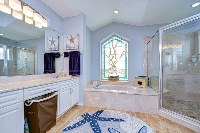 bathroom featuring vanity, hardwood / wood-style floors, separate shower and tub, and vaulted ceiling