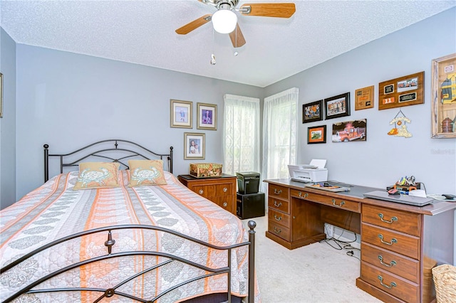 carpeted bedroom featuring a textured ceiling and ceiling fan