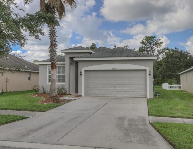 view of front of property featuring a garage and a front lawn