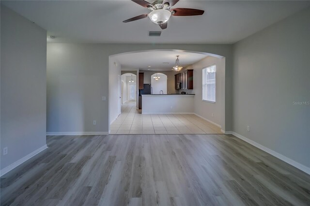 unfurnished living room featuring ceiling fan and light hardwood / wood-style flooring