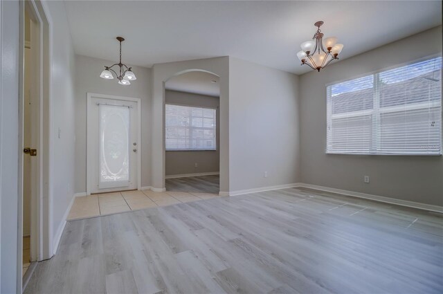 entryway featuring light hardwood / wood-style flooring, a chandelier, and plenty of natural light