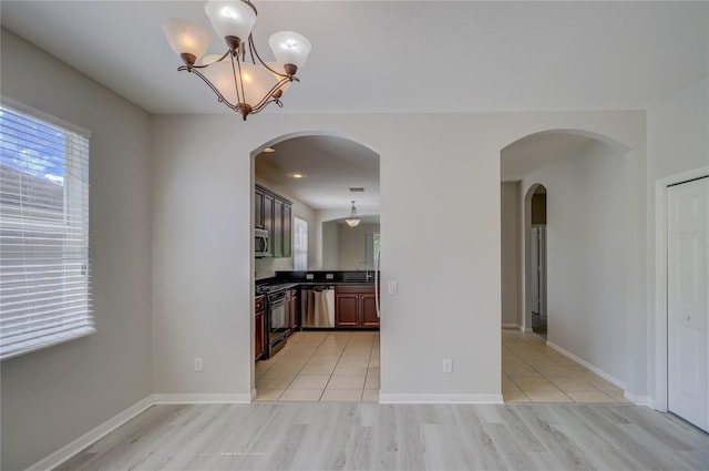 kitchen with a chandelier, sink, hanging light fixtures, light hardwood / wood-style flooring, and appliances with stainless steel finishes