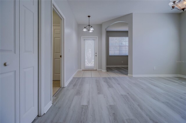 entrance foyer featuring a notable chandelier and light wood-type flooring