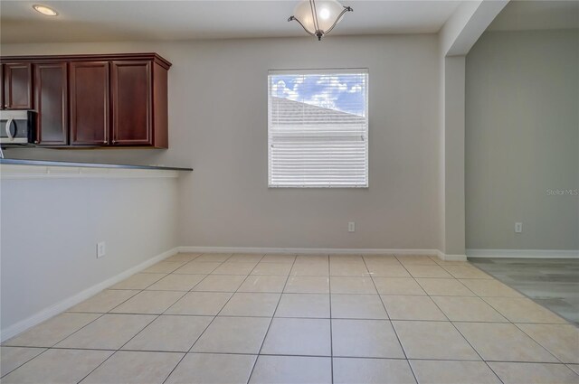 unfurnished dining area featuring light tile patterned floors