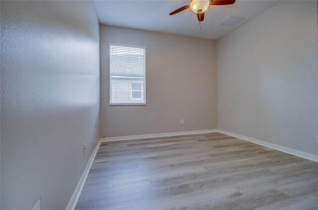 empty room with ceiling fan and light hardwood / wood-style flooring