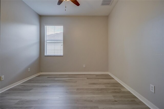 spare room featuring light wood-type flooring and ceiling fan