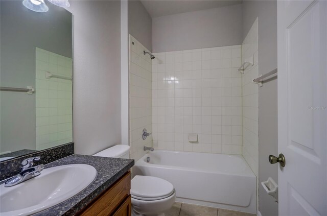 full bathroom featuring tiled shower / bath combo, vanity, toilet, and tile patterned floors