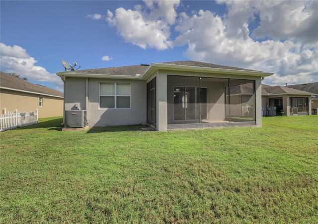 rear view of property featuring a sunroom, central air condition unit, and a yard