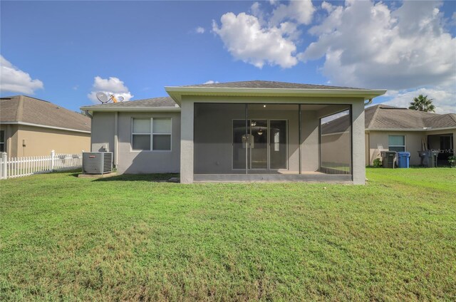 back of house with a sunroom, a yard, ceiling fan, and central air condition unit