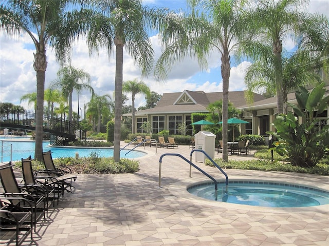 view of pool with a community hot tub and a patio