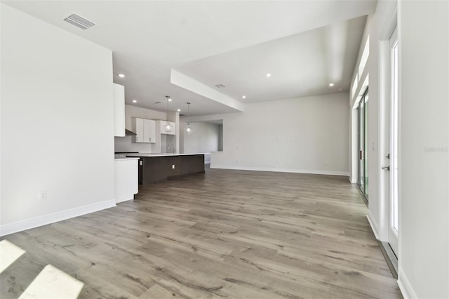 unfurnished living room featuring plenty of natural light and light wood-type flooring