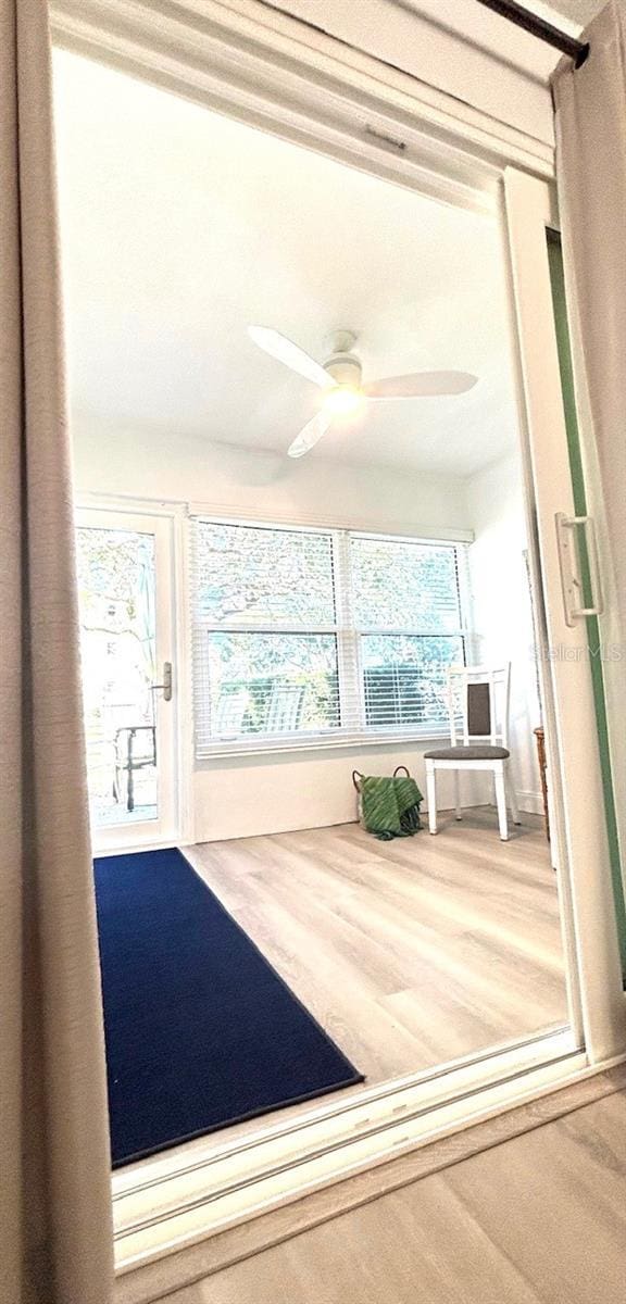 unfurnished sunroom featuring ceiling fan