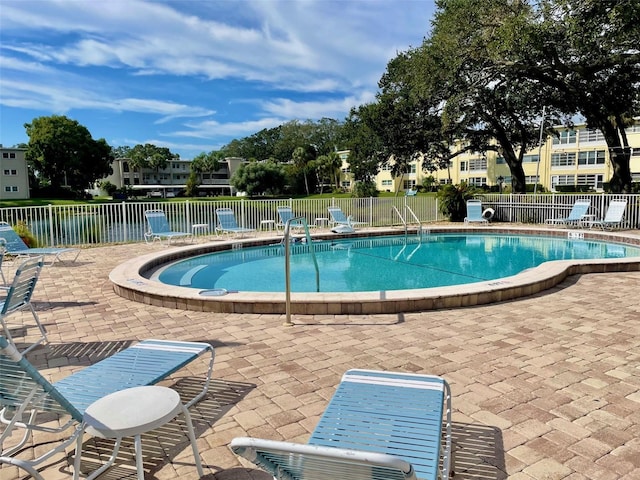 view of pool with a patio and a water view