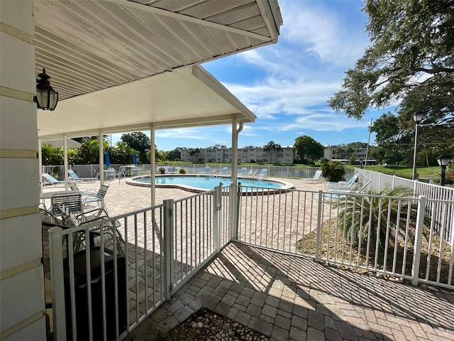 view of pool with a patio area and a water view