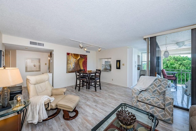 living room with a textured ceiling and light hardwood / wood-style floors