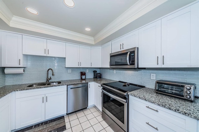 kitchen with light stone counters, sink, white cabinets, stainless steel appliances, and crown molding