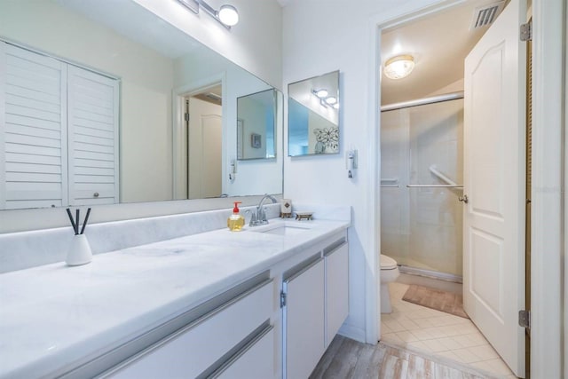 bathroom featuring walk in shower, tile patterned flooring, vanity, and toilet