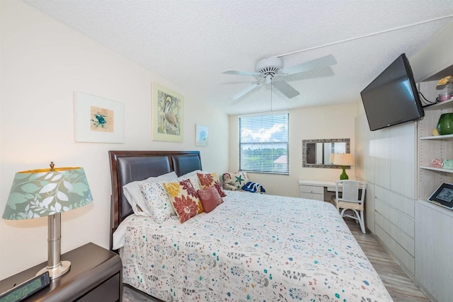 bedroom with ceiling fan, a textured ceiling, and light hardwood / wood-style flooring