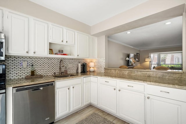 kitchen featuring appliances with stainless steel finishes, white cabinets, light wood-type flooring, ornamental molding, and sink