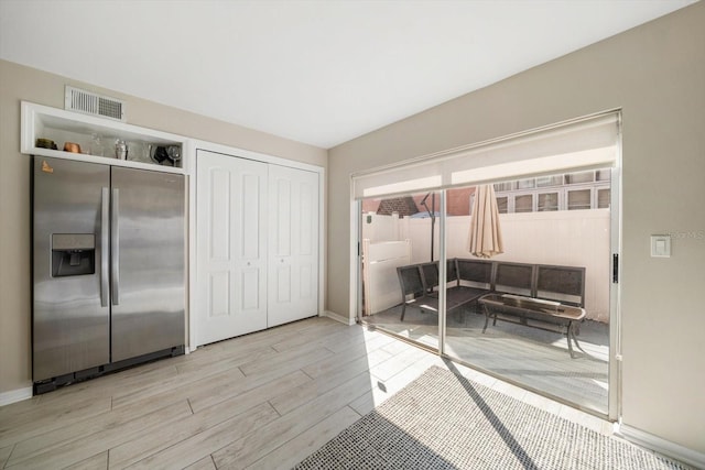 interior space featuring stainless steel built in fridge and light wood-type flooring