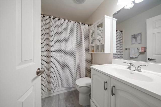 bathroom with a shower with curtain, vanity, hardwood / wood-style floors, and toilet