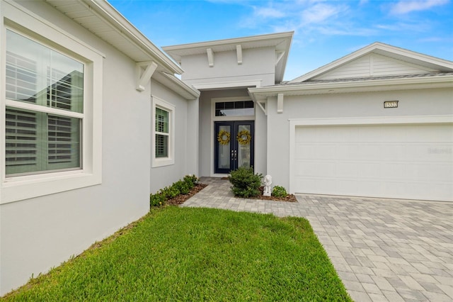 entrance to property featuring a garage and a lawn