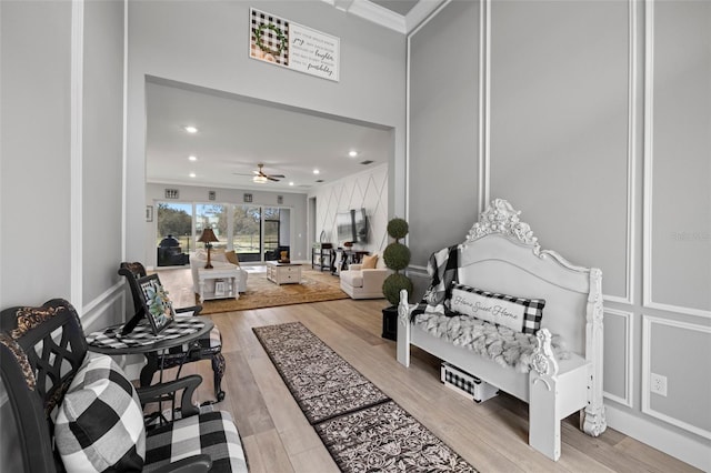 interior space with crown molding, light wood-type flooring, and ceiling fan