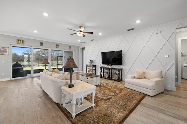 living room featuring ornamental molding, light hardwood / wood-style floors, and ceiling fan