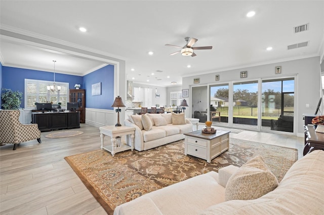 living room featuring light hardwood / wood-style floors, ornamental molding, and ceiling fan with notable chandelier