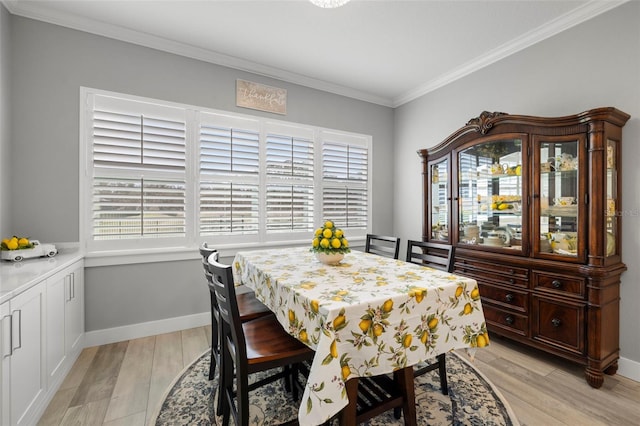 dining space featuring light hardwood / wood-style floors, crown molding, and a wealth of natural light