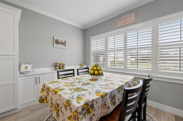 dining space featuring light hardwood / wood-style floors and crown molding