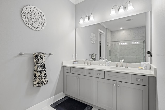 bathroom with baseboards, a sink, visible vents, and a shower stall