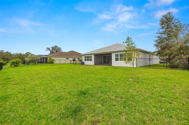 rear view of house with a yard and a sunroom