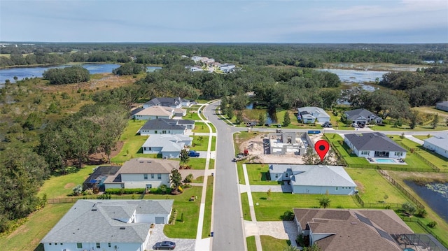 bird's eye view featuring a water view, a wooded view, and a residential view